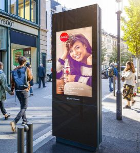 Panel de DOOH en la calle con un anuncio de cocacola